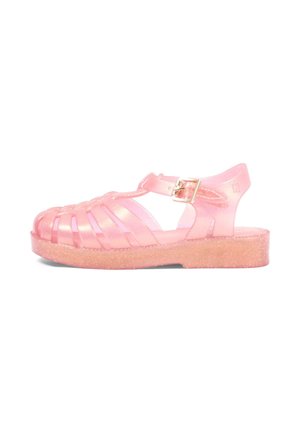 Sandalo jelly rosa trasparente con design a gabbia chiusa sulla punta, suola piatta glitterata e cinturino regolabile alla caviglia con fibbia dorata.