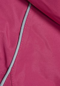 Magenta tyg med en slät yta, med en grå kant. Materialet verkar hållbart och är något texturerat, vilket indikerar en väderbeständig design.