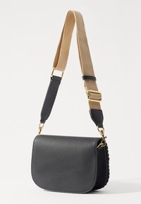 Borsa a tracolla nera in pelle texturizzata con una tracolla intrecciata color cammello e dettagli in oro. Presenta una forma strutturata con chiusura a pattina.