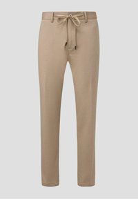 Beige Jogginghose aus weichem Material, mit einem Kordelzugbund, zwei seitlichen Taschen und einer schmal zulaufenden Beinform.