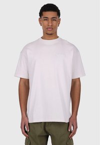 Camiseta de algodón de color rosa claro con cuello redondo, mangas cortas y un pequeño logo bordado en la parte izquierda del pecho. Corte casual.