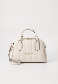 Quiltet beige håndtaske med guldfarvet hardware, topbærerhåndtag og en aftagelig skulderrem. Har prægede branding og lynlåsdetaljer.