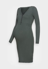 Robe de maternité en maille côtelée vert foncé, avec col en V, manches longues, fermeture à cinq boutons et silhouette ajustée.