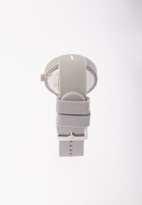 Reloj de silicona gris con una caja redonda, correa texturizada, marcadores de hora en blanco y hebilla plateada. Diseño minimalista y acabado suave.