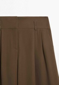 Pantalon marron taille haute avec passants de ceinture et plis, en tissu lisse.