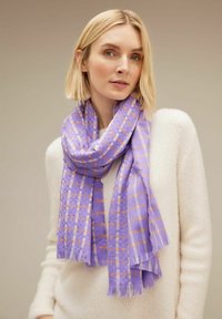 Sciarpa viola con un motivo a quadri caratterizzata da accenti arancioni. Realizzata in un tessuto strutturato, presenta bordi sfrangiati ed è poggiata intorno al collo.