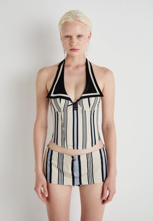 Striped halter neck top in cream and black, featuring a plunging neckline, button detail, and a cropped design with matching shorts.