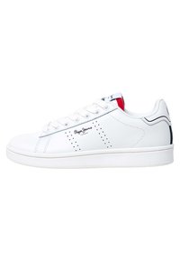 Sneaker in pelle bianca con dettagli perforati, lacci piatti e punta rotonda. Presenta un accento rosso nel tallone e una linea nera a contrasto.