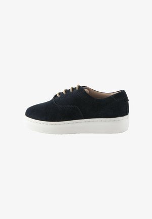 Marineblaue Wildleder-Sneaker mit runder Zehenpartie, cremefarbenen Schnürsenkeln und einer dicken weißen Sohle. Verfügt über eine Naht entlang der Kante und eine glatte Textur.