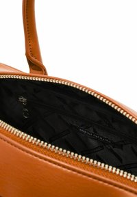 Borsa a tracolla in pelle color tan con una cerniera dorata parzialmente aperta, che mostra l'interno foderato di nero e l'etichetta "Armani Exchange" all'interno.