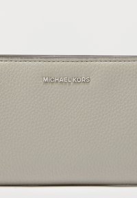 Γκρι δερμάτινο πορτοφόλι με υφή και ασημί λογότυπο "MICHAEL KORS". Στερεή κατασκευή με καθαρές γραμμές και ελάχιστες λεπτομέρειες.