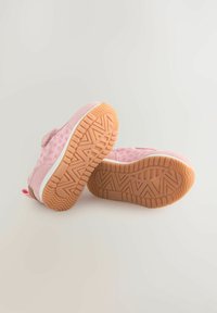 Baskets en suede rose avec un dessus texturé à motif animal, semelles en caoutchouc avec un motif en zigzag et une semelle intermédiaire blanche.