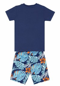 Marineblaues Kurzarm-T-Shirt kombiniert mit blauen Shorts, die grüne und orangefarbene tropische Blatt- und Blumenmuster aufweisen. Aus weichem Baumwollmaterial.