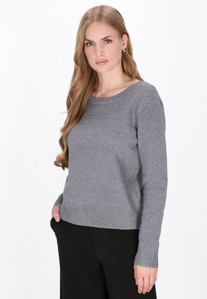 Pulover gri din tricot cu guler rotund, manșete și tiv cu nervuri, având o croială lejeră și o textură moale. Asortat cu pantaloni închiși la culoare.
