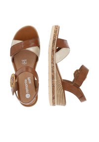 Sandales compensées marron et beige avec brides croisées et boucle ronde tissée, avec un motif floral sur le bord de la semelle.