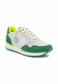 Zapatilla deportiva verde y blanca con materiales de malla y gamuza, cuello acolchado amarillo y suela de goma con un acento verde contrastante.