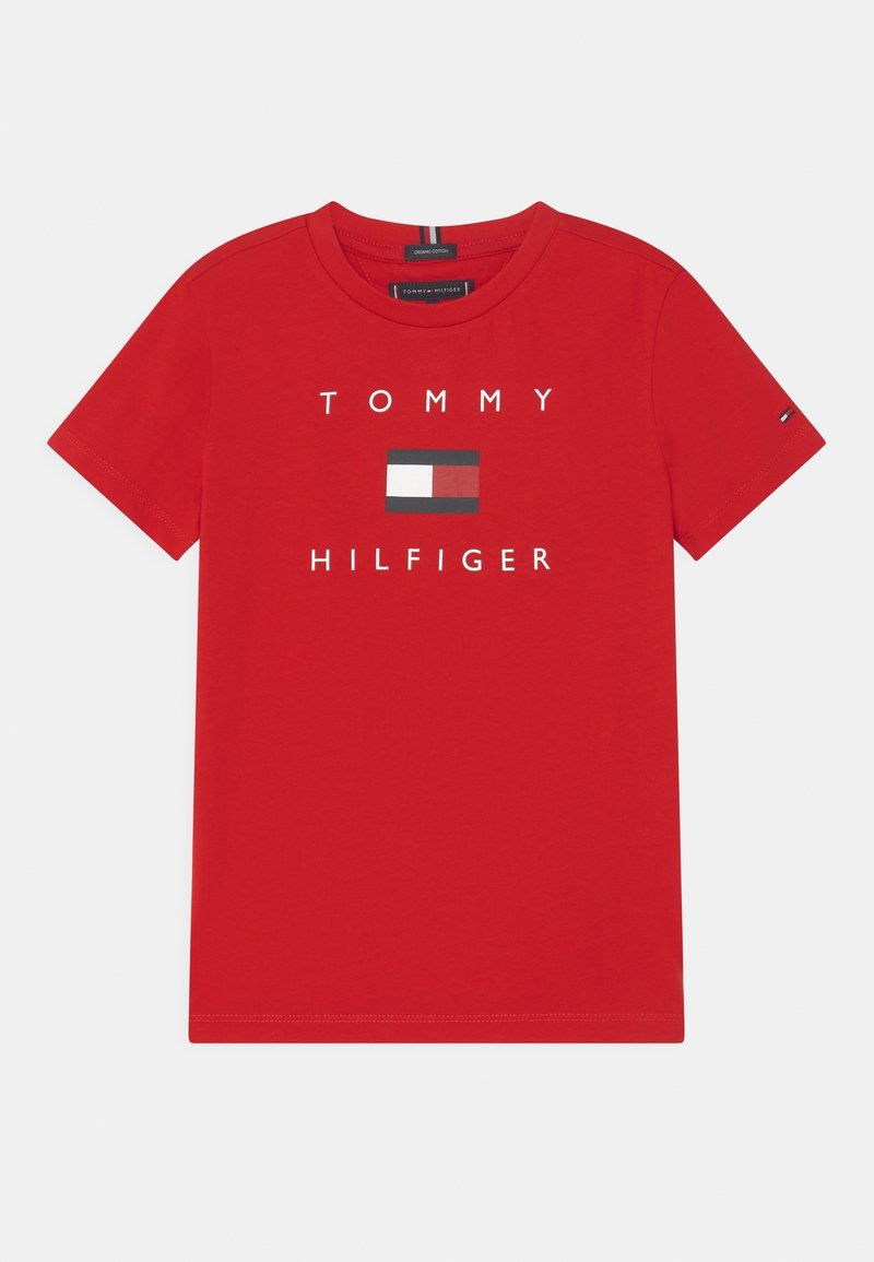 Camiseta roja de manga corta y cuello redondo con el logo de Tommy Hilfiger y el emblema de la bandera centrados en la parte delantera.
