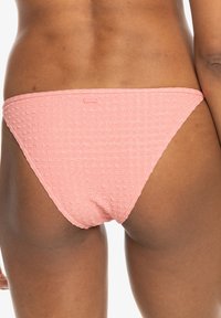 Rosa mönstrad bikiniunderdel gjord av texturerat tyg, med en låg midja och en logotagg på baksidan.