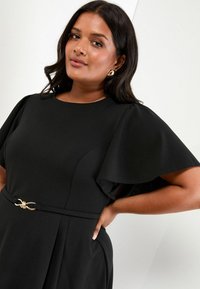 Rochie neagră cu mâneci scurte înflorate, bust ajustat și un accent decorativ din hardware auriu la talie. Material neted cu pliseuri.
