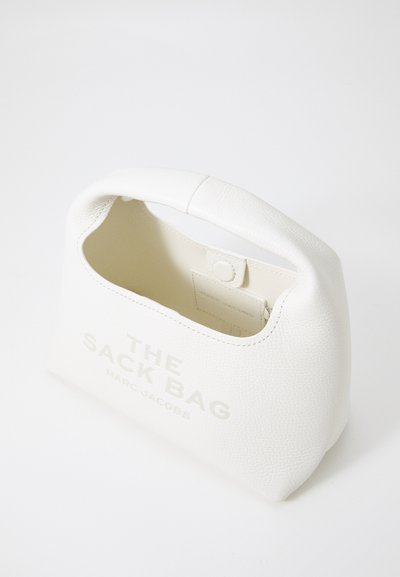 Sac fourre-tout en cuir blanc avec une poignée arrondie, présentant une texture lisse et des lettres en relief à l'avant. À l'intérieur, il est non doublé.