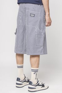 Stripede cargo shorts i blå og hvit med flere lommer, utstyrt med en patch-etikett, sammen med lyse sokker og joggesko.