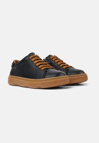 Zapatillas de cuero negro con cordones naranjas. Presentan una parte superior texturizada, suela de goma contrastante y una forma redondeada.