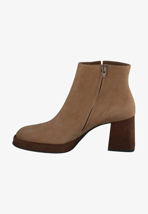 Stivaletti alla caviglia in suede beige con punta arrotondata, zip laterale e tacco quadrato spesso. Texture morbida con un accento di tacco marrone a contrasto.