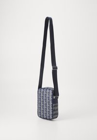 Borsa a tracolla blu con motivo geometrico, forma rettangolare, superficie liscia e una tracolla regolabile per una maggiore comodità di trasporto.