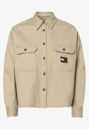 Beige overhemd met knopen, lange mouwen, twee voorzakken met klep en een Tommy Jeans logo op de rechterzak.