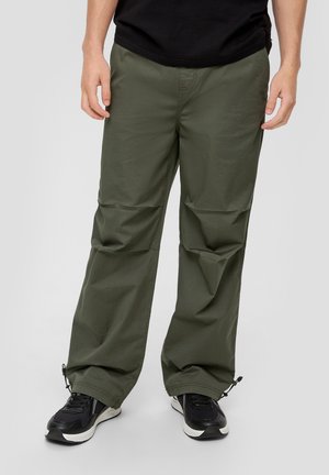 Pantalones ligeros de color verde oliva, con corte recto, que cuentan con puños con cremallera y una tela suave y texturizada. Diseñados para ofrecer comodidad y libertad de movimiento.