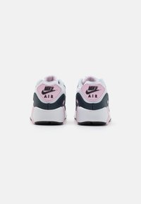 Nike Air tenisice s bijelim i mornarsko plavim gornjim dijelom, ružičastim akcentima, teksturiranim detaljima i crnim potplatima. Imaju logo na peti i pojačani ovratnik.