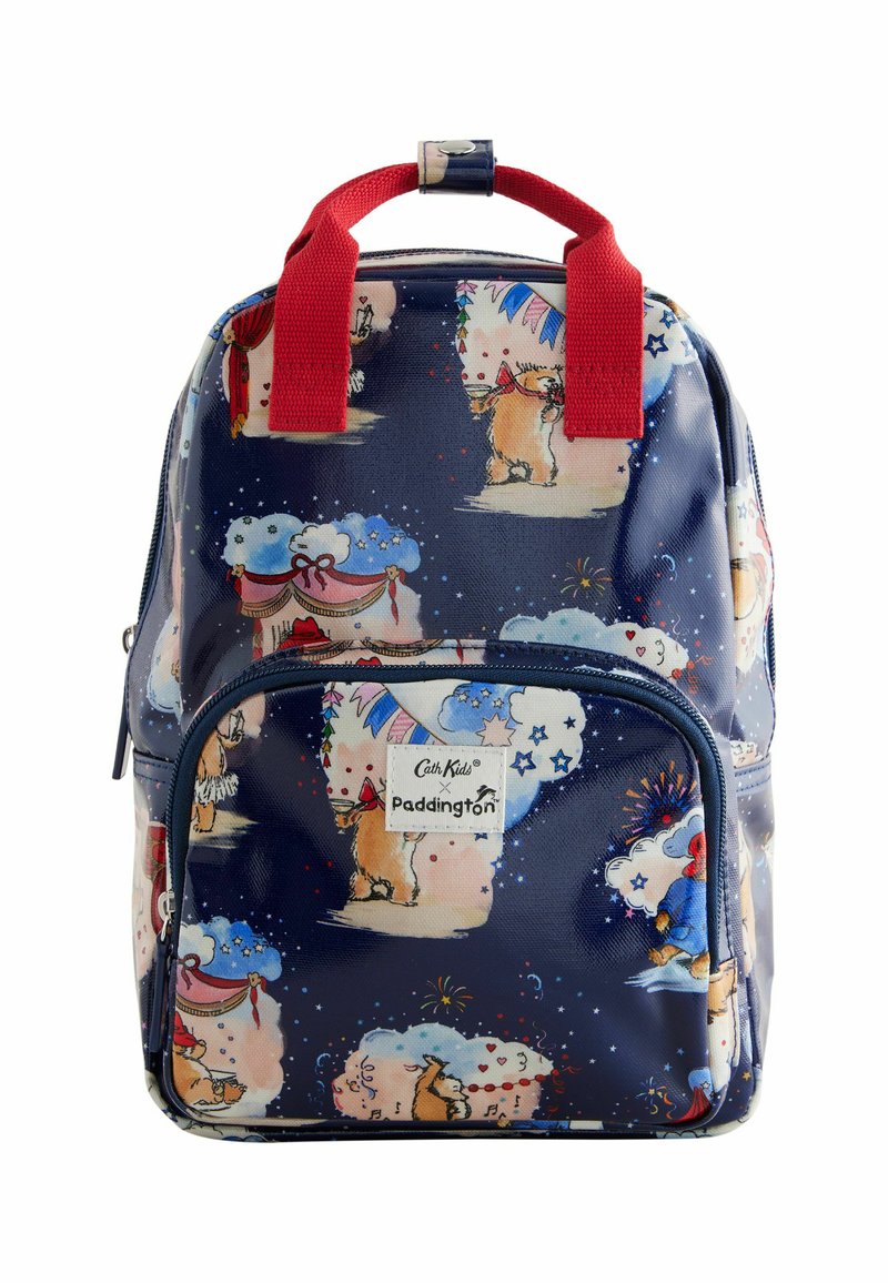 Sac à dos bleu marine avec des poignées et une fermeture éclair en tissu rouge, arborant un motif ludique de Paddington Bear sur une surface imperméable. Poche zippée à l'avant incluse.