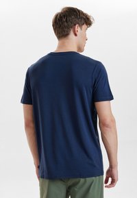mørkeblå bomulds t-shirt med korte ærmer og rund hals, der har en glat overflade og minimal detaljer på bagsiden.