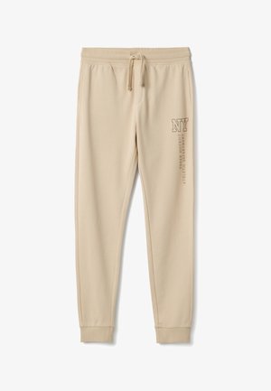 Pantalones deportivos beige hechos de tela suave, con cintura elástica y cordón, bolsillos laterales y texto impreso en la pierna izquierda.