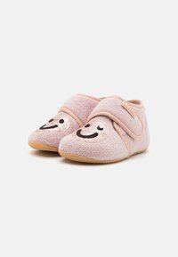 Zapatillas de casa para toddler en suave color rosa, con caras sonrientes de lentejuelas y correas ajustables, sobre un fondo blanco.