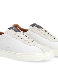 Weiße Ledersneaker mit Suede-Akzenten, Schnürdesign und strukturiertem Gummisohle. Auffällige gewellte Kanten und eine schwarze Fersenschlaufe.