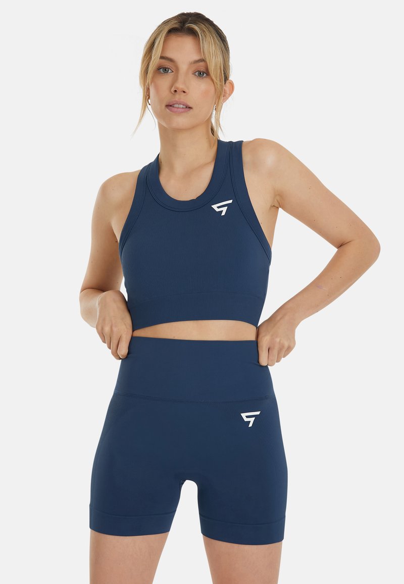 Navyblaues athletisches Crop-Top und hochgeschnittene Shorts aus geripptem Stoff, mit einem weißen Logo und elastischem Bund.