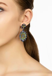 Colorful chandelier earrings featuring blue, green, and gold glittering stones in floral shapes, with black accents and a dangle design.