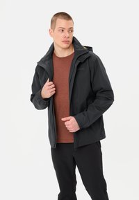 Veste imperméable noire avec capuche. Caractéristiques : poignets élastiques et fermeture éclair à l'avant, avec une doublure intérieure contrastante et un logo.