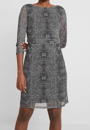 Czarna i biała sukienka w wzory z teksturą krokodyla, z rękawami do połowy przedramienia i luźnym krojem, z okrągłym dekoltem.
