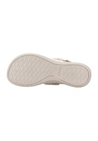 La suela de la sandalia presenta una superficie de goma texturizada en beige con un patrón en ondas; incluye marca. La parte superior tiene un diseño a rayas.