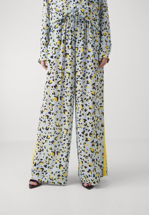 Ansamblu cu imprimeu de leopard, format dintr-o țesătură de culoare albastră deschisă cu pete negre și galbene, pantaloni cu picioare largi și talie cu șnur, și slituri laterale.