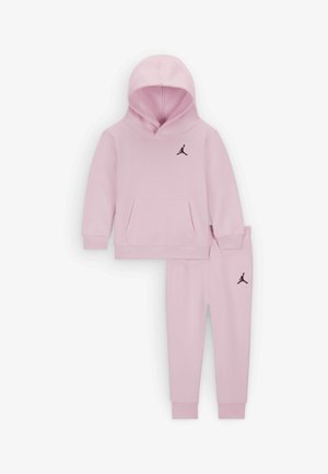 Lichtroze hoodie en sweatpants set, voorzien van een voorzak, ribgebreide mouwen en een zwart logo op de borst en dij. Zachte textuur van de stof.