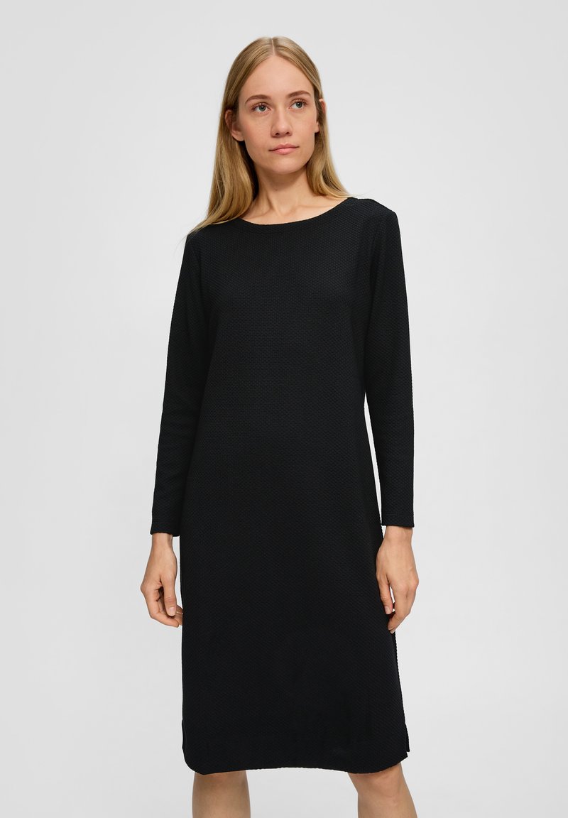 Schwarzes langärmliges Kleid mit einem strukturierten Muster, rundem Ausschnitt und seitlichen Schlitzen am Saum. Hergestellt aus einem leichten Stoff.
