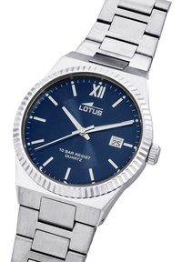 Reloj de acero inoxidable plateado con un bisel texturizado, esfera azul, marcadores de hora plateados, indicador de fecha y pulsera de eslabones. Movimiento de cuarzo, resistencia al agua de 10 bares.
