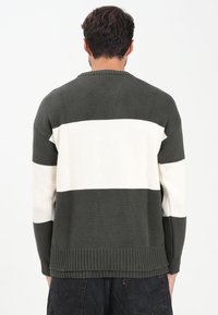 Maglione lavorato a maglia a righe verde scuro e crema, con una finitura texturizzata, scollatura tonda e orlo e polsini a coste.