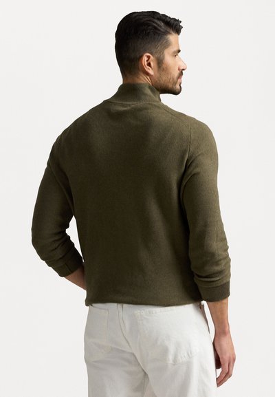 Pullover em verde oliva com nervuras, com gola alta e mangas longas, feito de tecido texturizado, apresentando punhos ajustados e bainha reta.