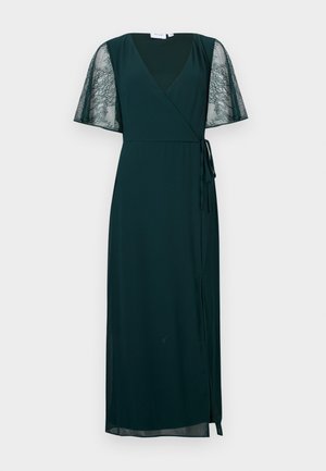 Donkergroene wikkeljurk met V-hals, doorschijnende korte mouwen van kant en een strik aan de zijkant, tot halverwege de kuit vallend.