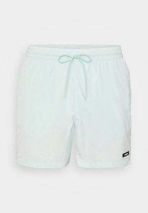 Bañadores de un suave verde menta, confeccionados con un material ligero y suave, que presentan una cintura elástica, un cordón ajustable y bolsillos laterales.