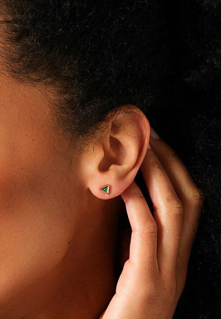 Orecchino a triangolo in metallo dorato con inserto in resina verde. L'orecchino è piccolo e elegante, caratterizzato da un design minimalista.